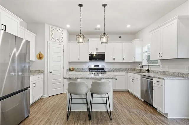 a kitchen with stainless steel appliances granite countertop a stove a sink and a microwave