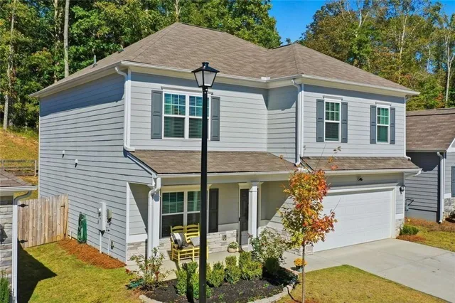 a view of a dining room with furniture a chandelier and a window