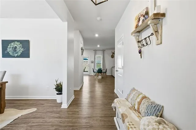 a kitchen with stainless steel appliances granite countertop a stove a sink dishwasher a refrigerator white cabinets and wooden floor next to a window