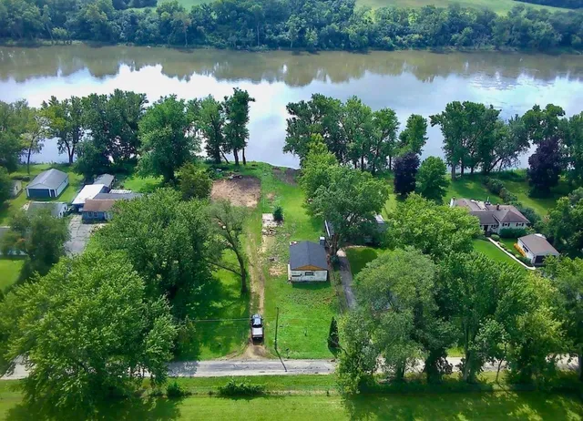 an aerial view of a house with yard lake and outdoor seating