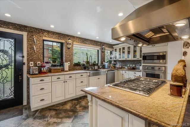 a kitchen with stainless steel appliances granite countertop sink stove top oven and cabinets