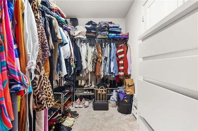 a view of walk in closet with clothes