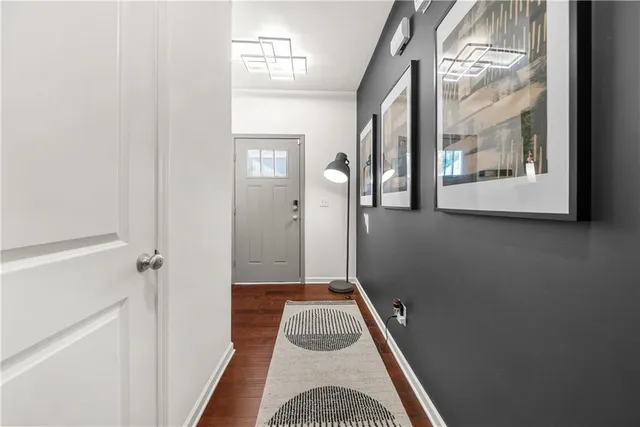 a view of a hallway with wooden floor and a cabinet