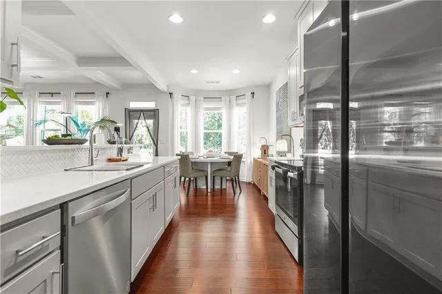 a kitchen with counter top space a sink appliances and cabinets