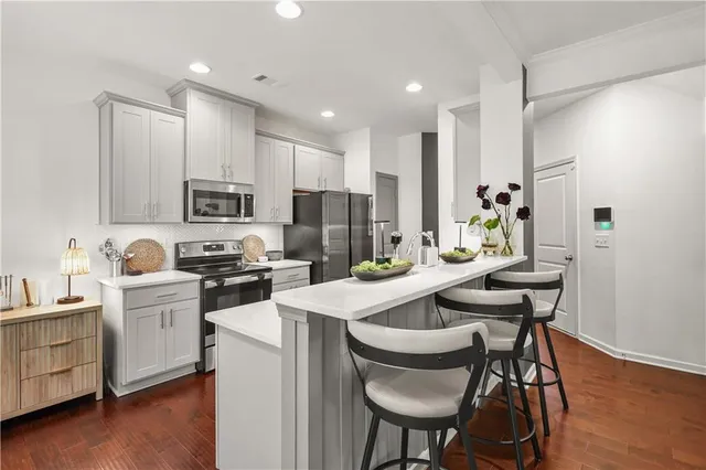 a kitchen that has a lot of cabinets in it with appliances and wooden floor