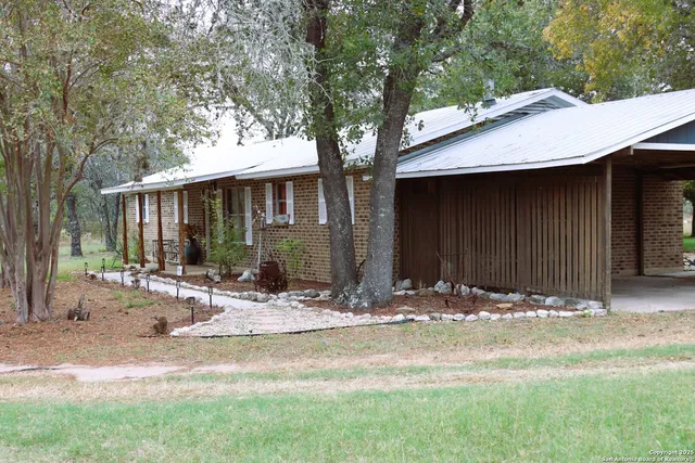 a view of house with yard and tree in front of it