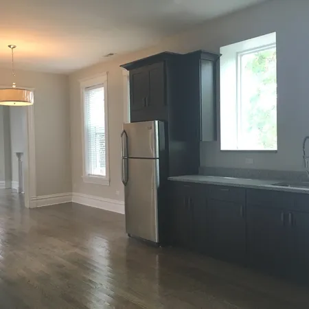 an empty room with wooden floor and a window