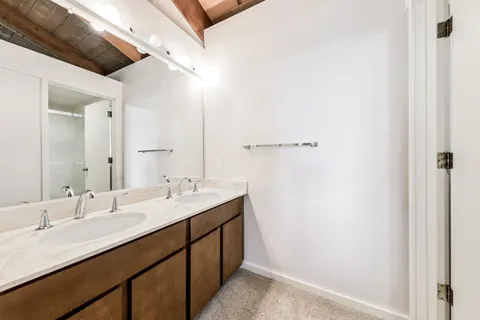 a bathroom with a double vanity sink and a mirror