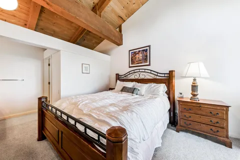 a bedroom with a bed and a lamp on the dresser