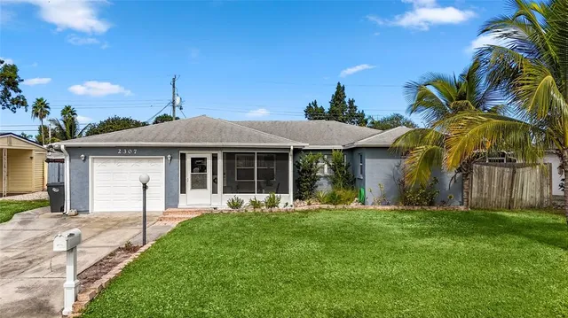 a front view of a house with a garden and yard
