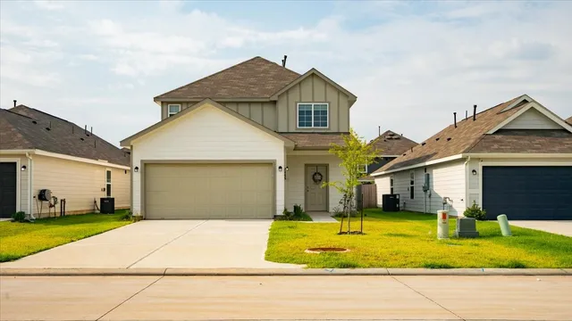 a front view of a house with yard and garage