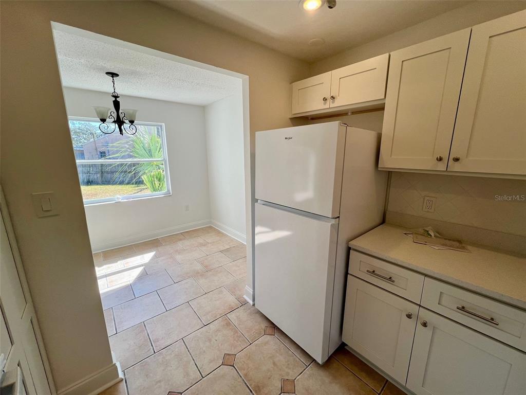 387 South McMullen Booth Road, Unit 13 Clearwater, FL 33759 - Photo 11 of 30 a kitchen with cabinets and a refrigerator