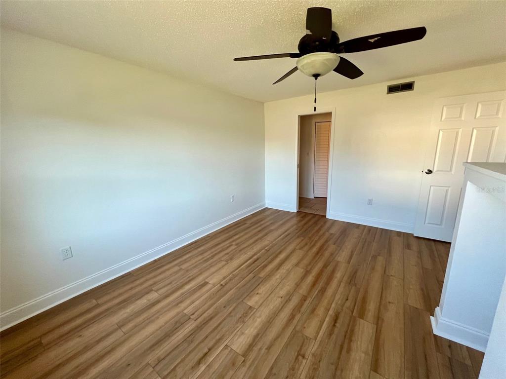 387 South McMullen Booth Road, Unit 13 Clearwater, FL 33759 - Photo 19 of 30 a view of empty room with wooden floor and fan