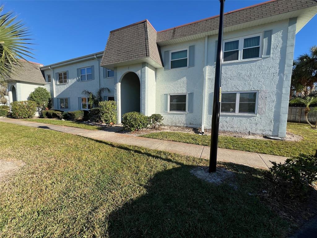 387 South McMullen Booth Road, Unit 13 Clearwater, FL 33759 - Photo 2 of 30 a front view of house with yard and green space