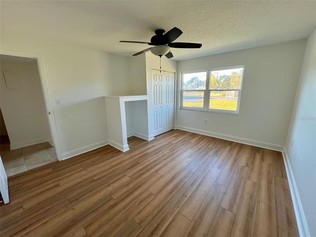 387 South McMullen Booth Road, Unit 13 Clearwater, FL 33759 - Photo 21 of 30 a view of empty room with wooden floor and fan