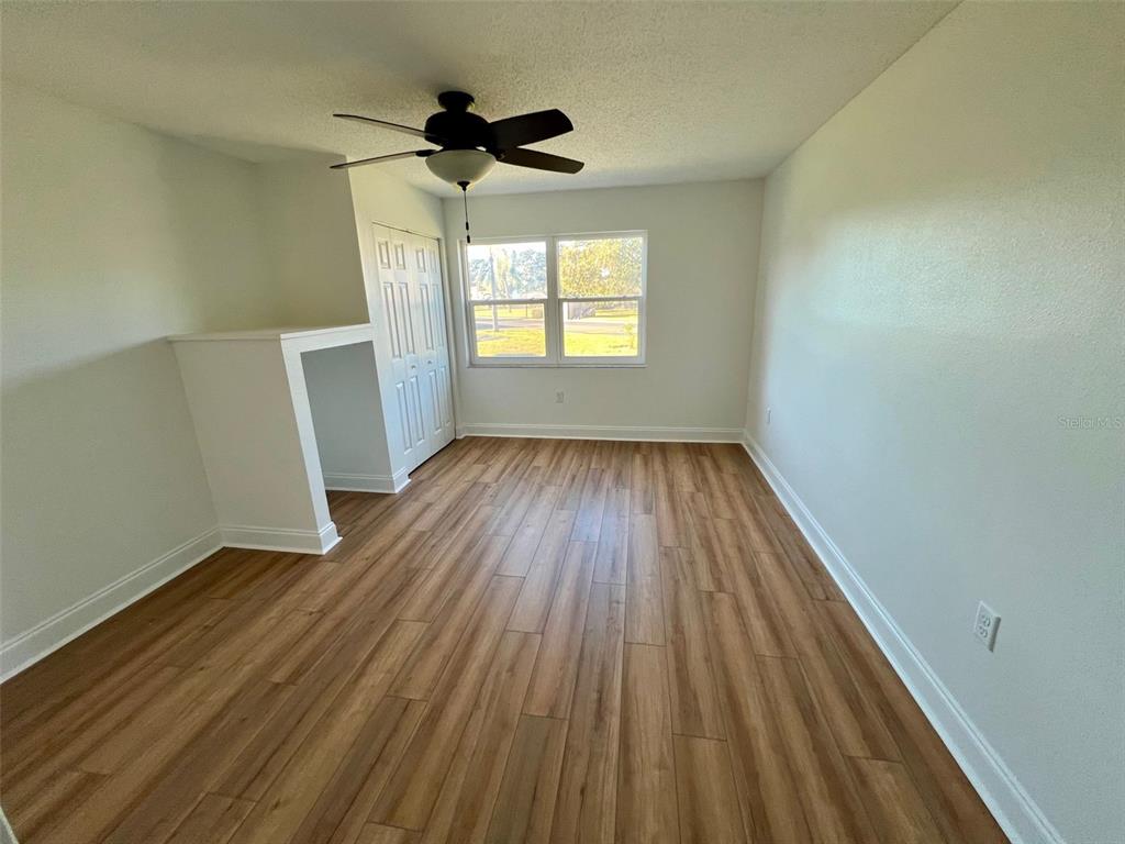 387 South McMullen Booth Road, Unit 13 Clearwater, FL 33759 - Photo 22 of 30 a view of empty room with wooden floor and fan