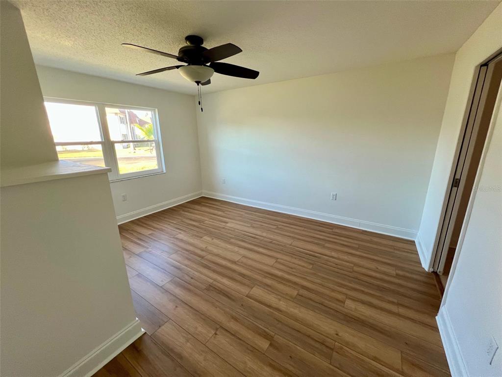 387 South McMullen Booth Road, Unit 13 Clearwater, FL 33759 - Photo 23 of 30 an empty room with wooden floor and windows