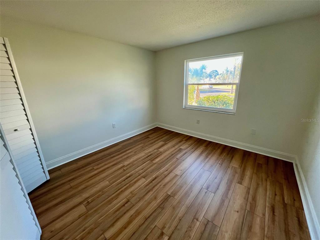 387 South McMullen Booth Road, Unit 13 Clearwater, FL 33759 - Photo 25 of 30 a view of an empty room with wooden floor and a window