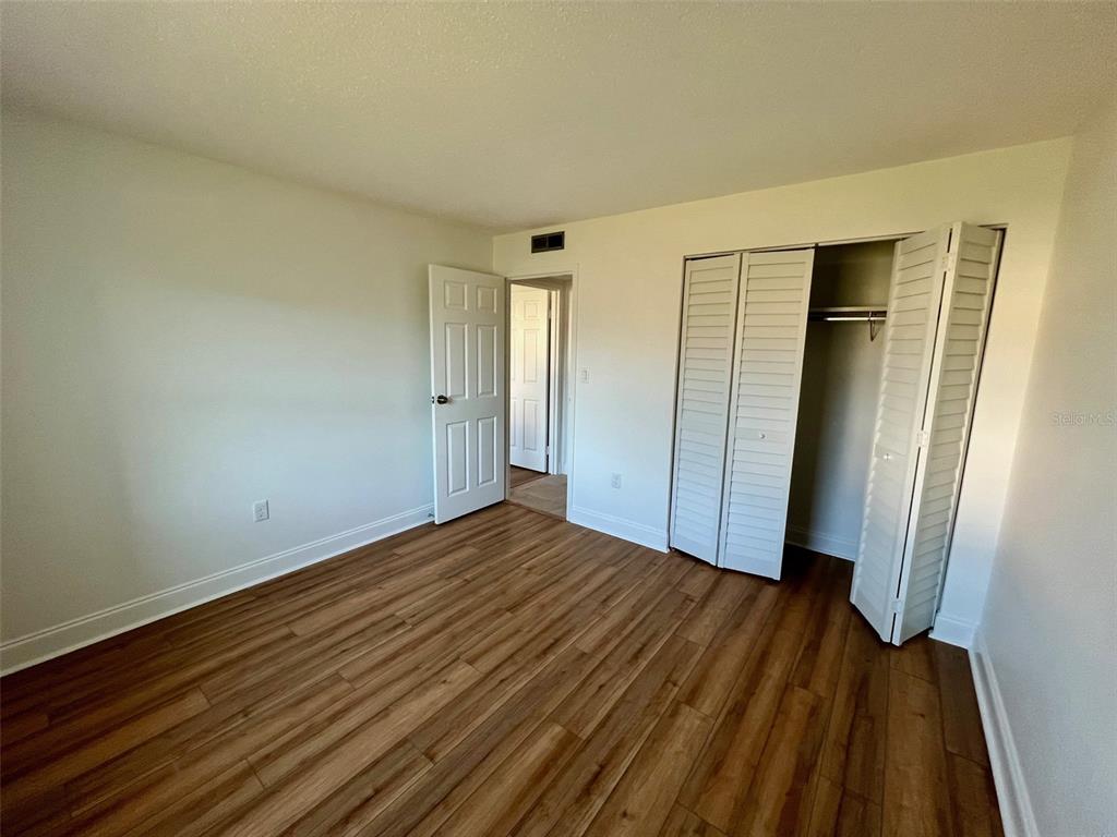 387 South McMullen Booth Road, Unit 13 Clearwater, FL 33759 - Photo 26 of 30 a view of an empty room with wooden floor and a window