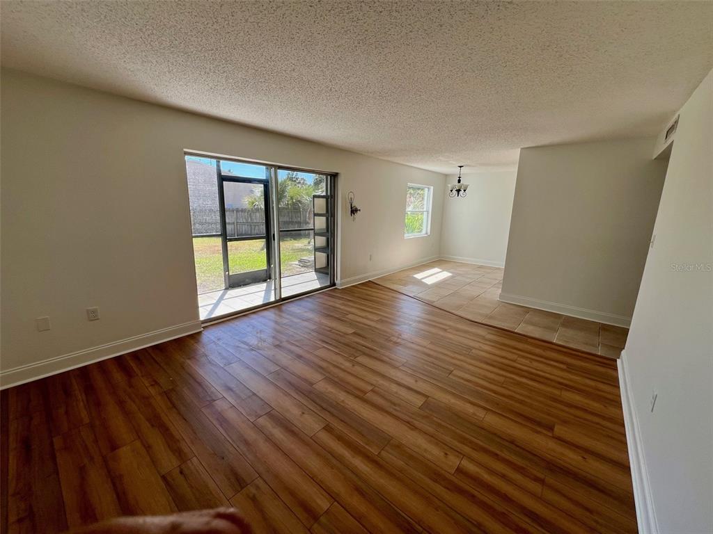 387 South McMullen Booth Road, Unit 13 Clearwater, FL 33759 - Photo 4 of 30 wooden floor in an empty room with a window