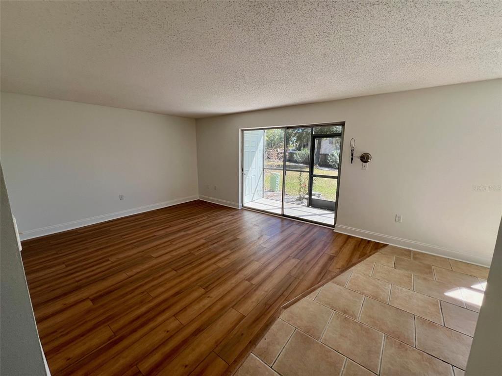 387 South McMullen Booth Road, Unit 13 Clearwater, FL 33759 - Photo 7 of 30 wooden floor in an empty room with a window