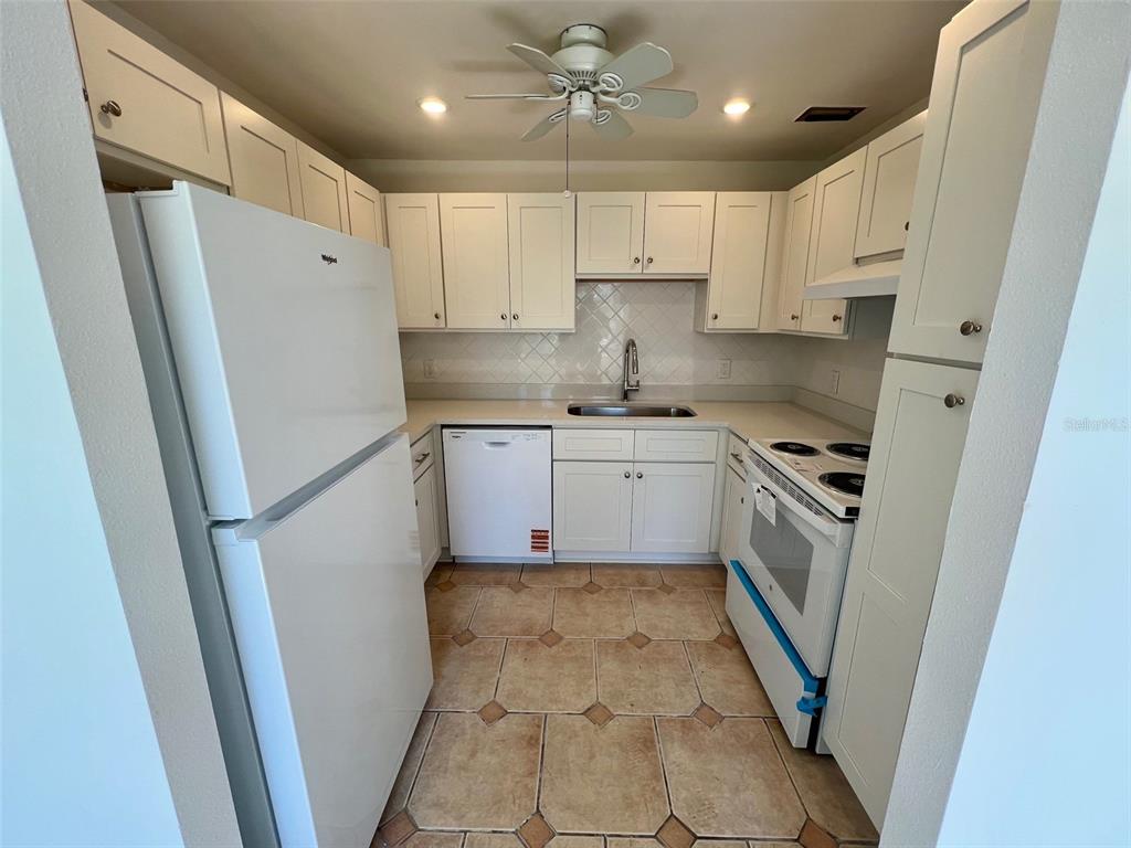 387 South McMullen Booth Road, Unit 13 Clearwater, FL 33759 - Photo 10 of 30 a kitchen with white cabinets and white appliances