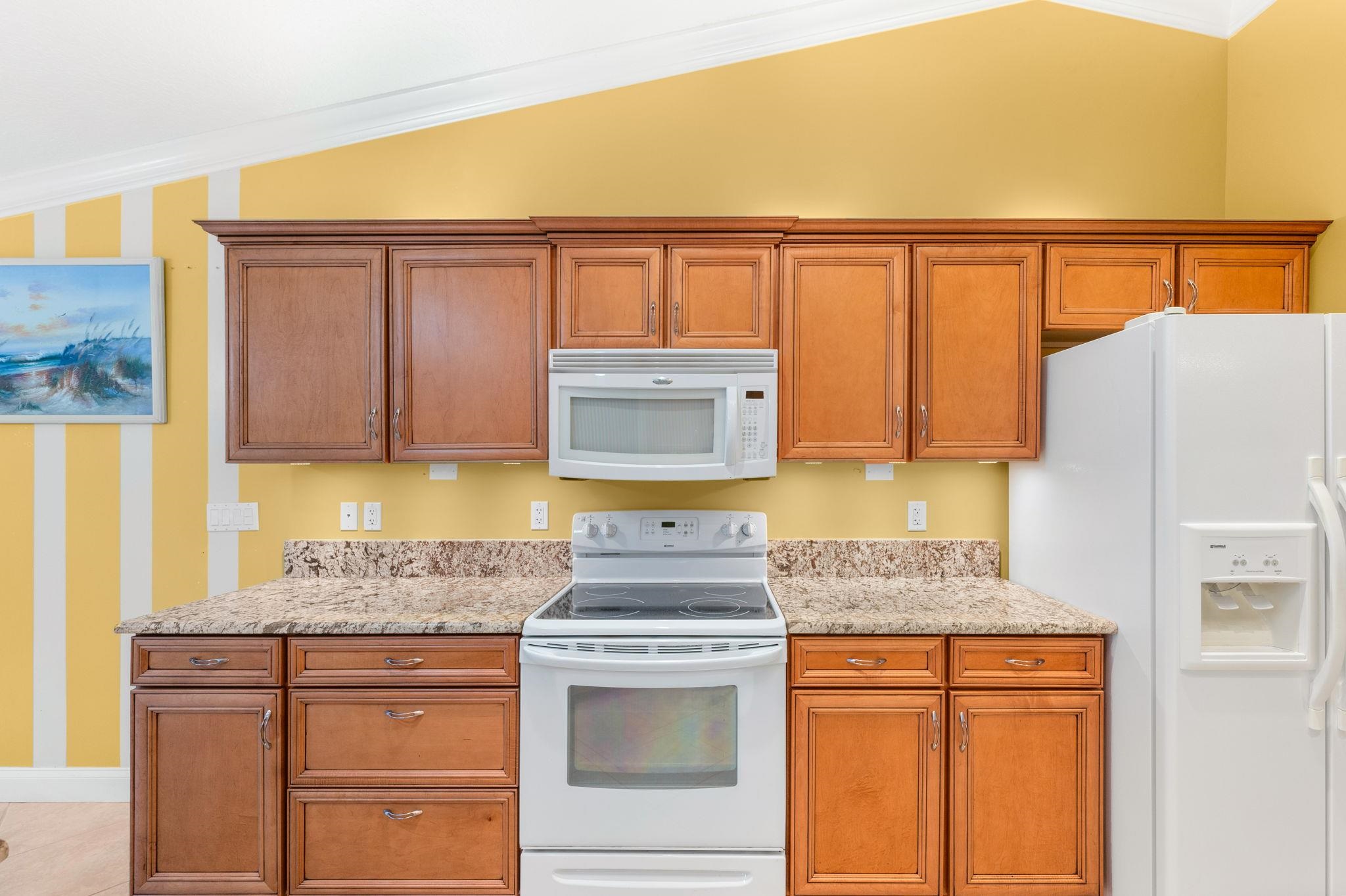 3489 Kings Road St. Augustine, FL 32086 - Photo 23 of 76 a kitchen with granite countertop a refrigerator and a stove top oven