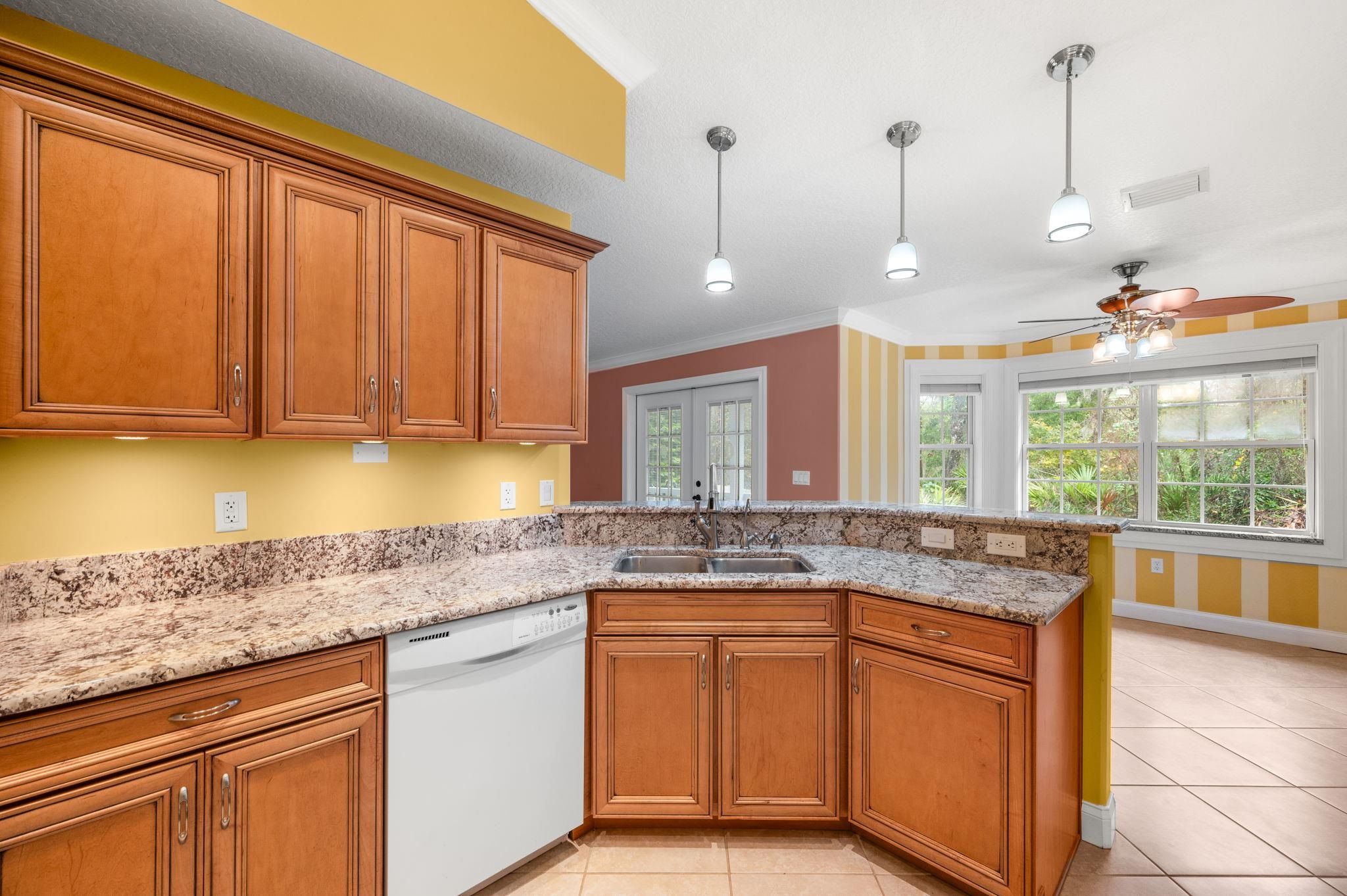3489 Kings Road St. Augustine, FL 32086 - Photo 24 of 76 a kitchen with stainless steel appliances granite countertop sink stove and cabinets