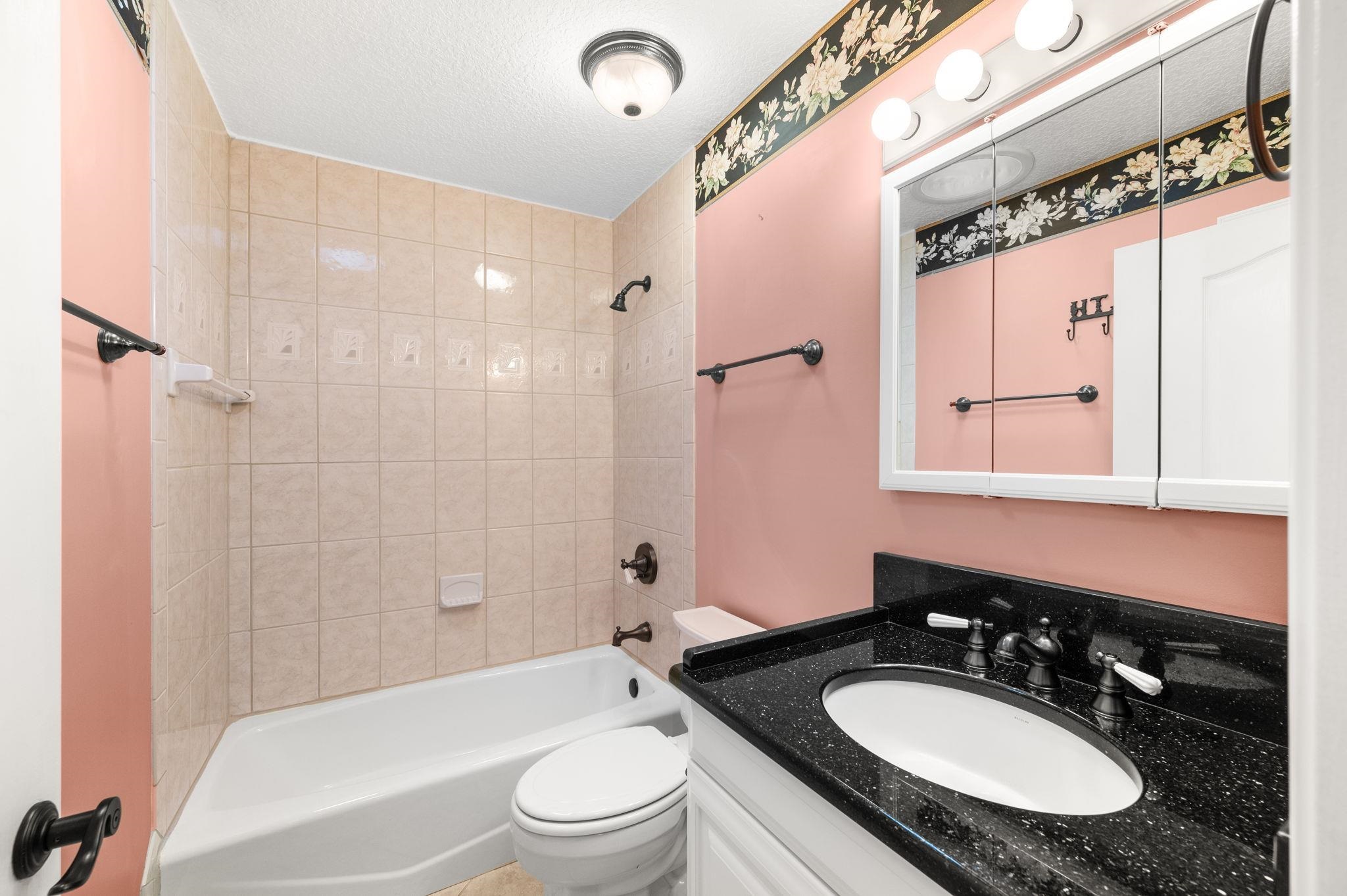3489 Kings Road St. Augustine, FL 32086 - Photo 31 of 76 a bathroom with a granite countertop sink a toilet a mirror and shower