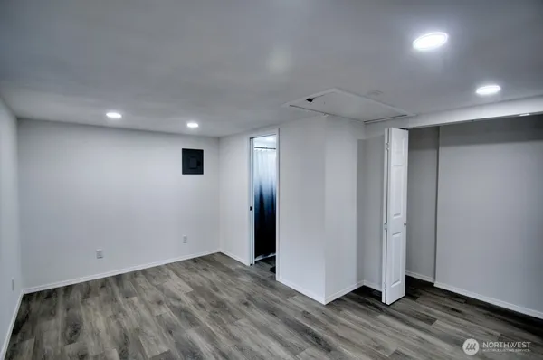 a view of a hallway with wooden floor and a toilet