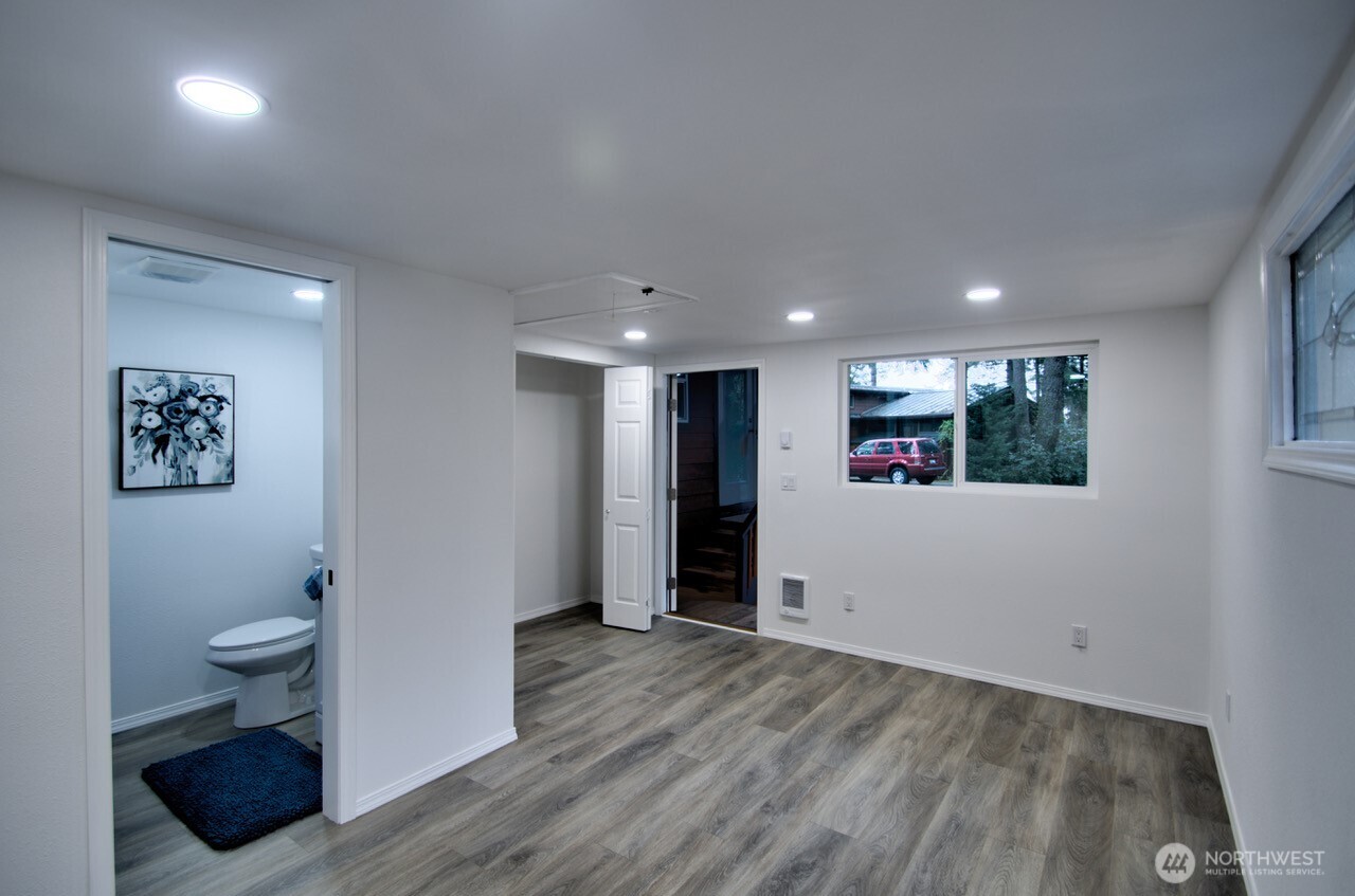 1546 Reservation Road Southeast, Unit 232 Olympia, WA 98513 - Photo 22 of 37 a view of a hallway with wooden floor and a toilet