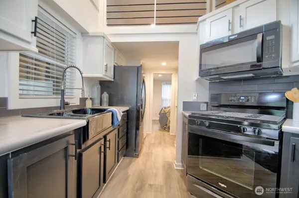 a kitchen with stainless steel appliances kitchen island granite countertop a sink a stove and a microwave