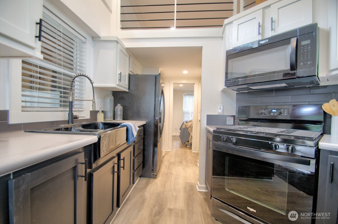 1546 Reservation Road Southeast, Unit 232 Olympia, WA 98513 - Photo 8 of 37 a kitchen with a stove and a microwave