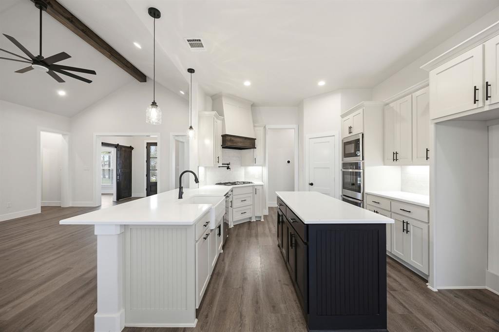 6709 Odom Road Sanger, TX 76266 - Photo 11 of 26 a kitchen with a sink a center island stainless steel appliances and cabinets