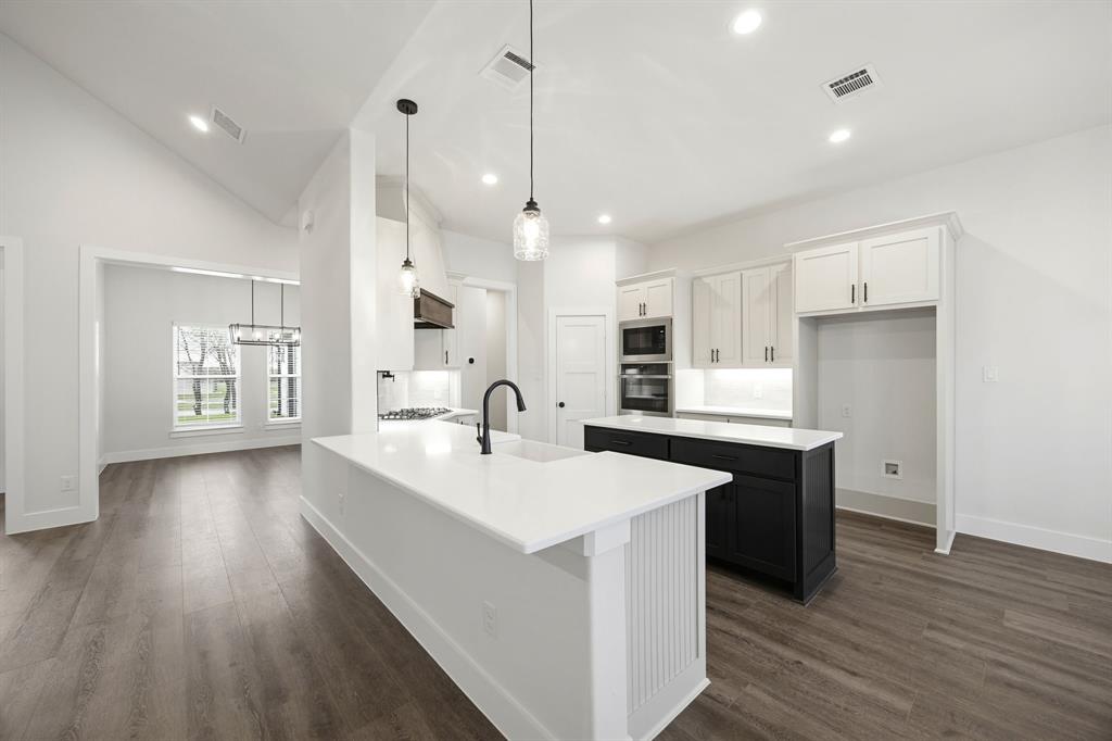 6709 Odom Road Sanger, TX 76266 - Photo 12 of 26 a large kitchen with stainless steel appliances a lot of counter space and a wooden floor