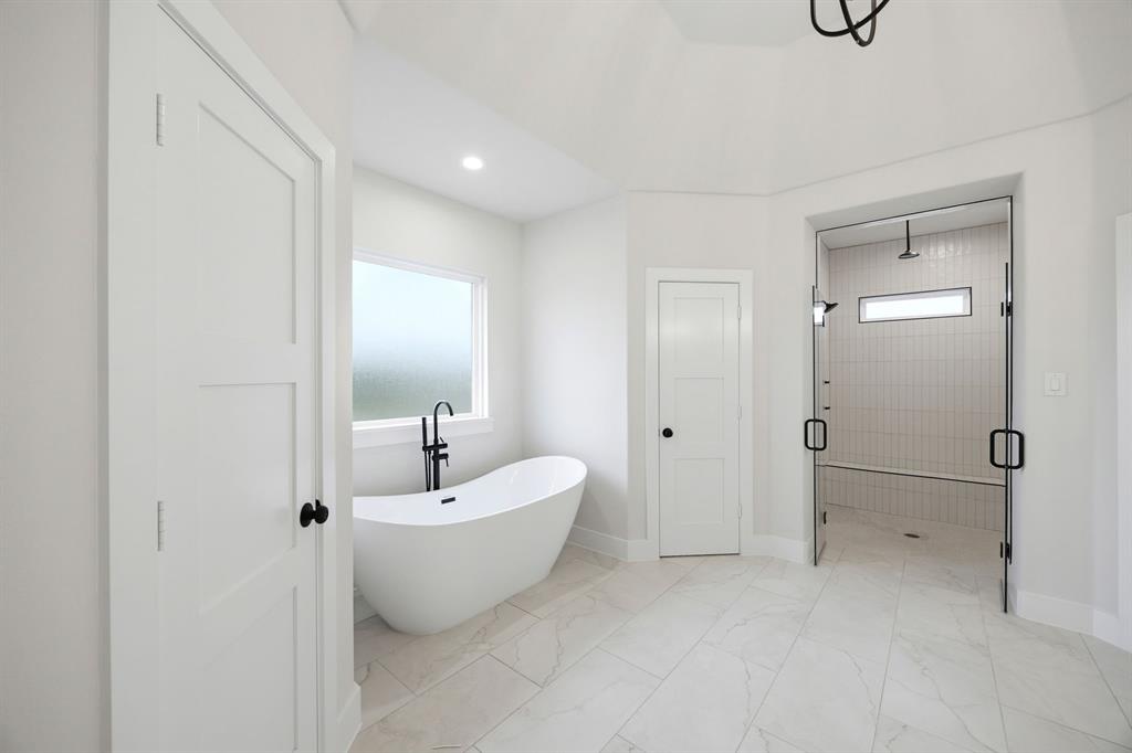 6709 Odom Road Sanger, TX 76266 - Photo 23 of 26 a spacious bathroom with a double vanity sink a mirror and a bathtub