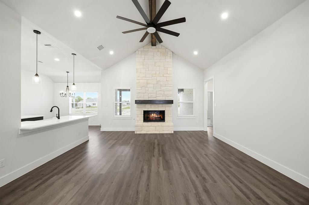 6709 Odom Road Sanger, TX 76266 - Photo 3 of 26 a large kitchen with cabinets wooden floor and a fireplace