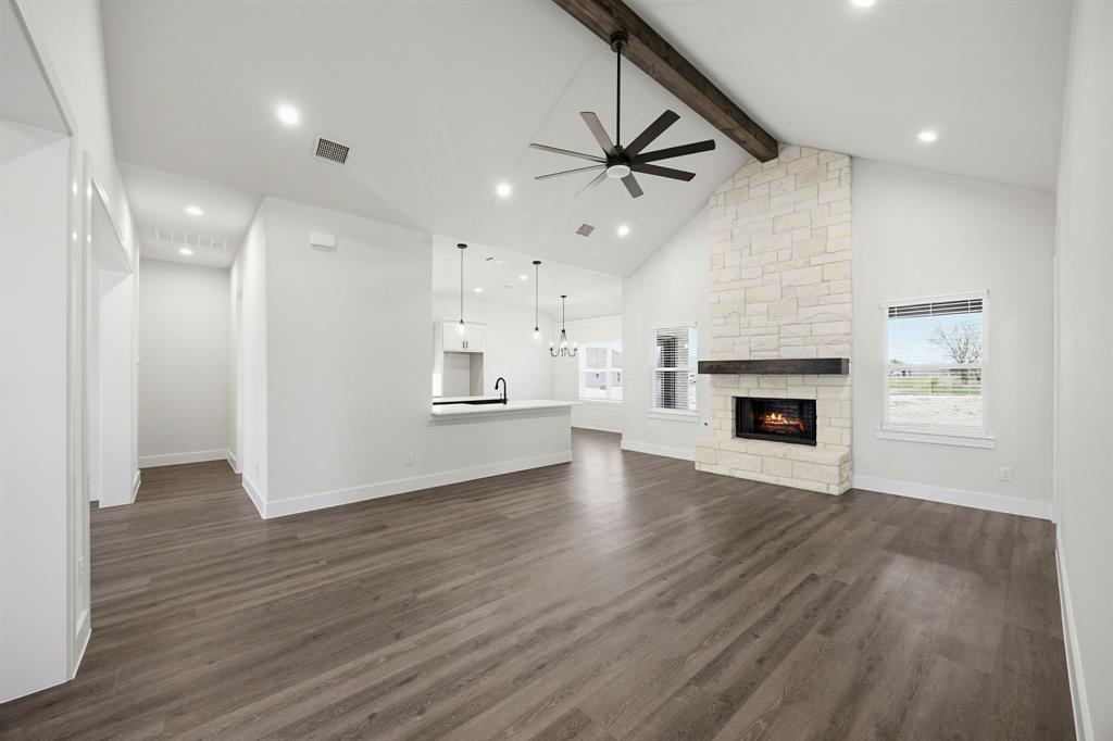 6709 Odom Road Sanger, TX 76266 - Photo 5 of 26 an empty room with wooden floor fireplace and windows