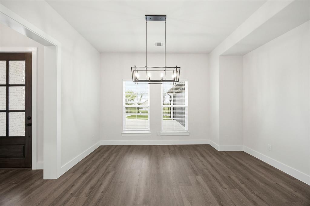 6709 Odom Road Sanger, TX 76266 - Photo 7 of 26 an empty room with wooden floor exposed radiator and windows