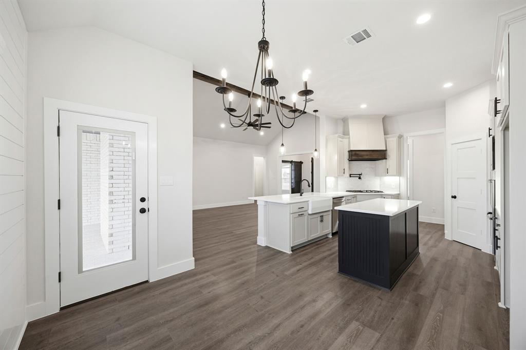 6709 Odom Road Sanger, TX 76266 - Photo 9 of 26 a large kitchen with cabinets wooden floor and stainless steel appliances
