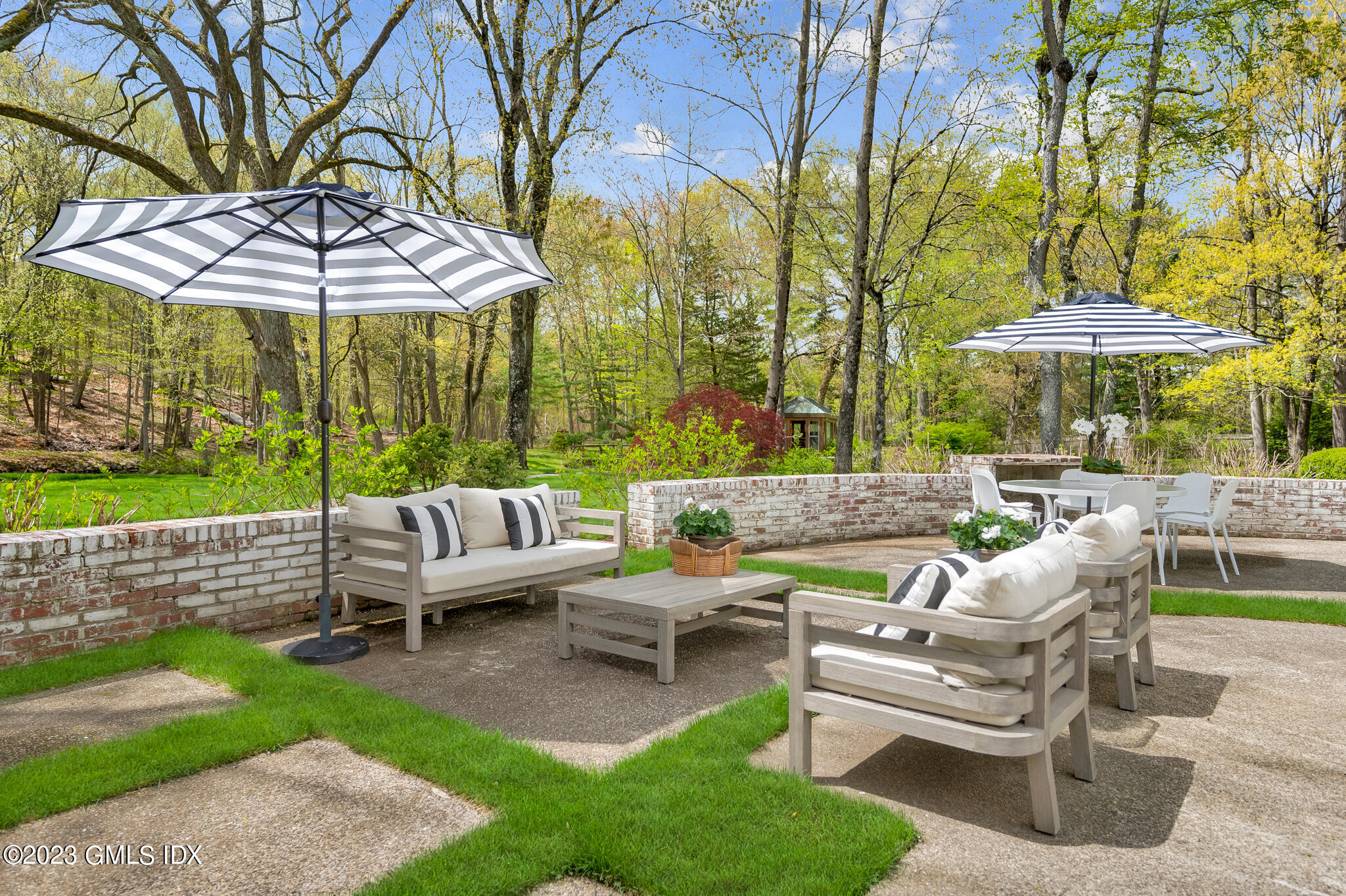 294 Riversville Road Greenwich, CT 06831 - Photo 13 of 17 a view of a patio with chairs and a table under an umbrella with a small yard