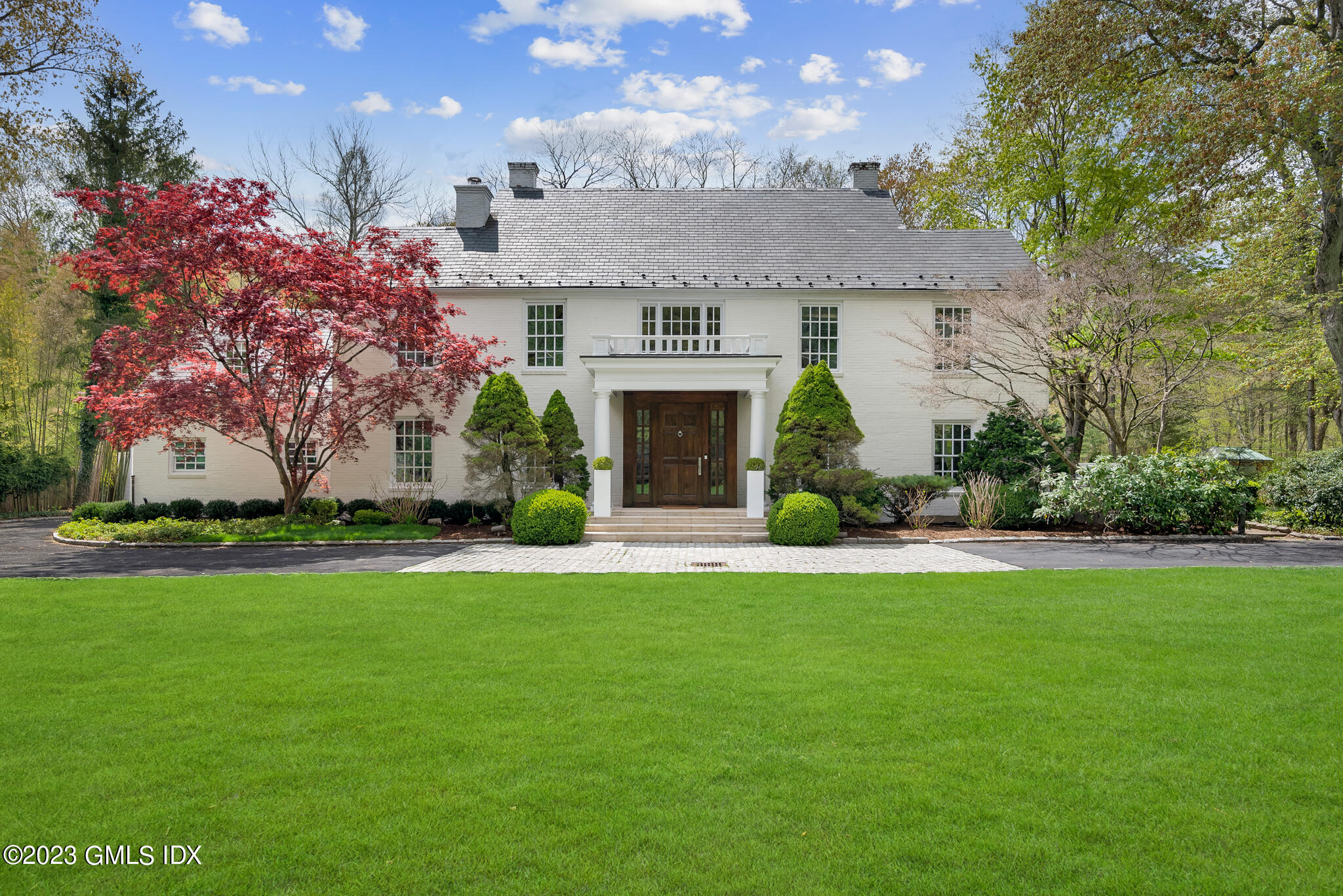 294 Riversville Road Greenwich, CT 06831 - Photo 2 of 17 a front view of a house with a garden and plants