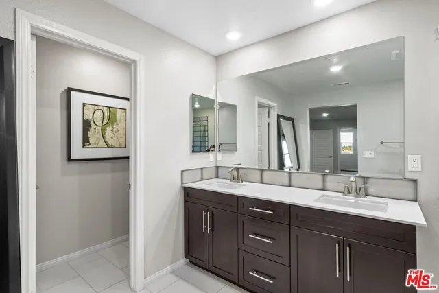 a bathroom with double vanity sink and a mirror