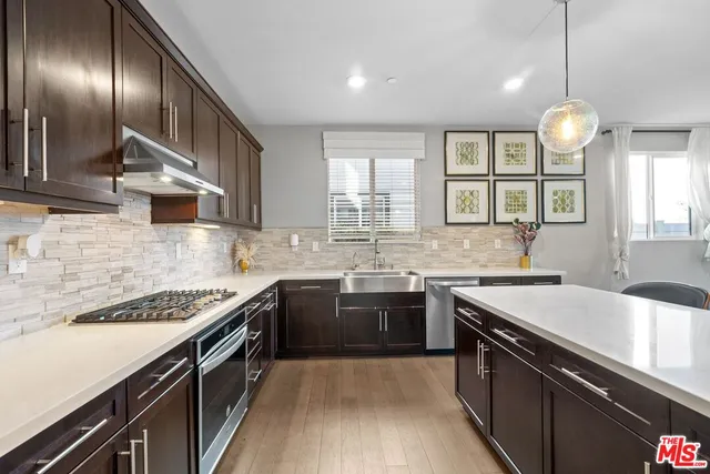 a kitchen with stainless steel appliances granite countertop a sink stove and cabinets