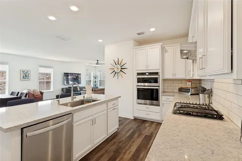 a kitchen with white cabinets and appliances