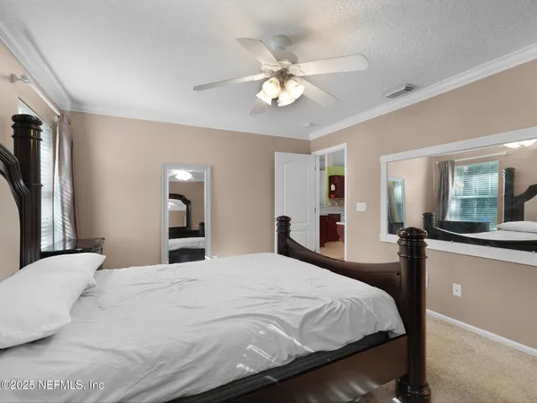a large bedroom with a large bed and a chandelier