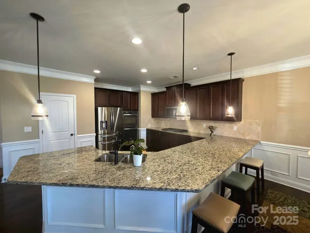 a kitchen with kitchen island a counter top space appliances and a counter space