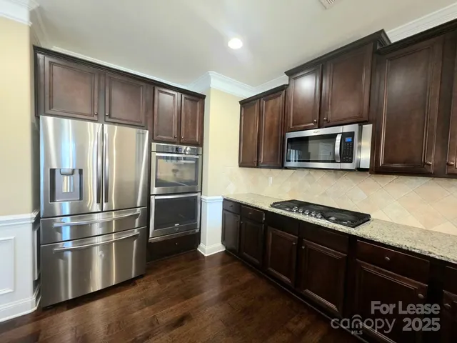 a kitchen with granite countertop stainless steel appliances and wooden cabinets