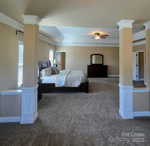 a spacious bedroom with a bed and a chandelier