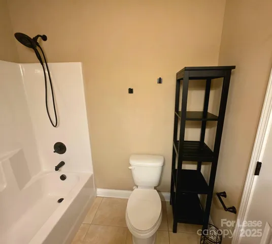 a bedroom with a bed and a lamp on dresser